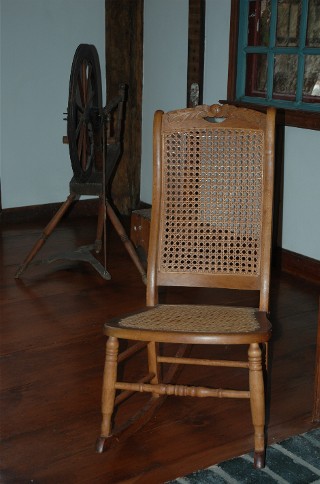 Rocking Chair with Spinning Wheel, alternate view of Living Room with Clock Wall